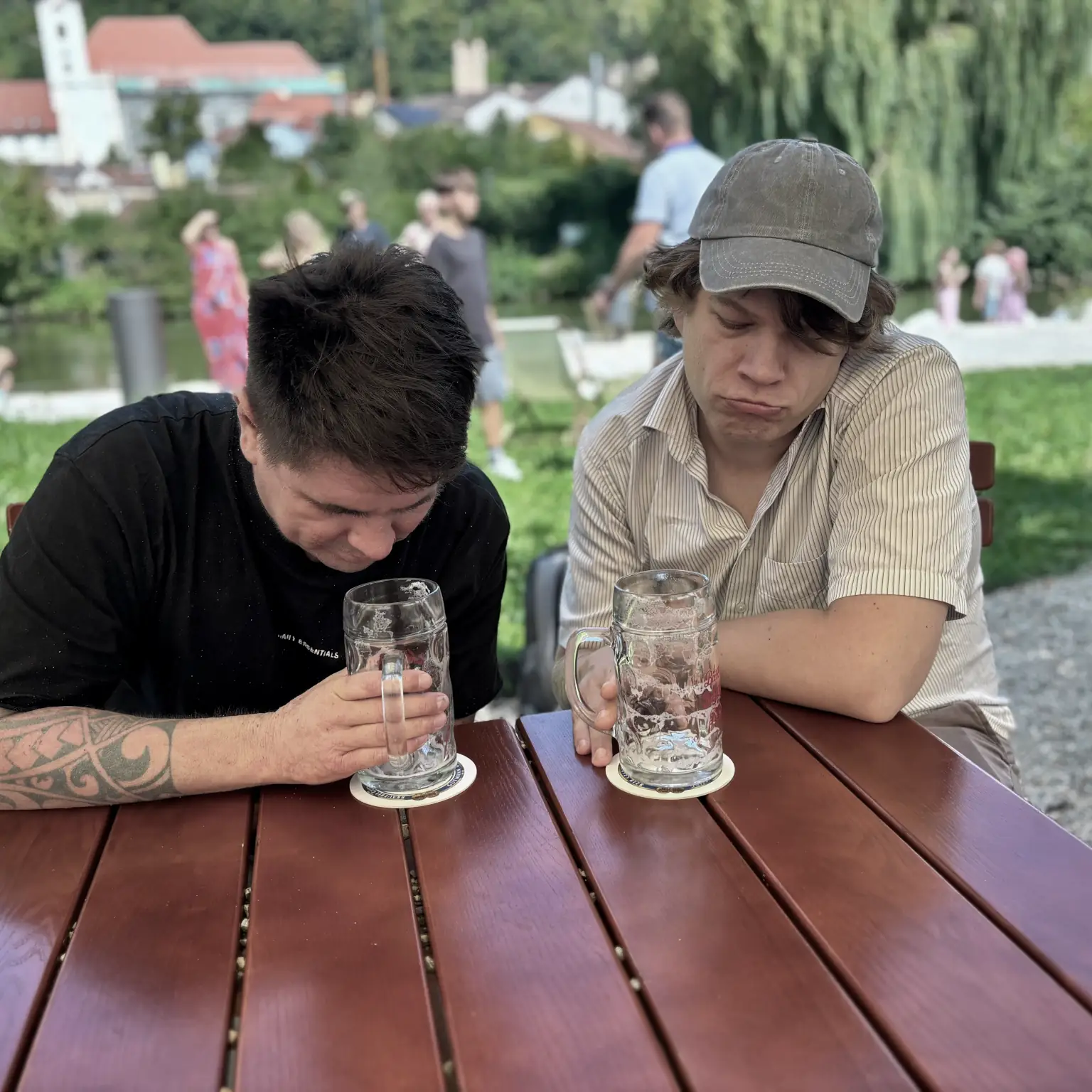 Roland und Benny sitzen bedrückt vor zwei leeren Gläsern